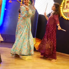 Two friends enjoying a Dandiya dance moment at our studio. We create a friendly atmosphere where you can laugh and learn with your wedding guests.