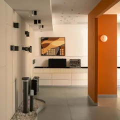 This wall serves as a functional display for a variety of architectural wall lights and track systems. The clean, white backdrop and organized layout allow clients to easily compare different products.
