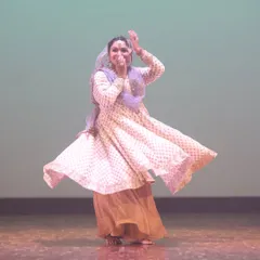 A joyful moment captured during a Kathak performance. The dancer's expression and spinning motion embody the vibrant energy of this classical dance form.