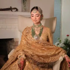 A moment of regal repose. I styled this bride in a magnificent golden lehenga, seated to showcase the rich texture and heavy embroidery, complemented by layered green beaded jewelry.