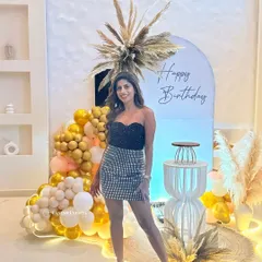The birthday girl posing against her chic, personalized boho party decor.