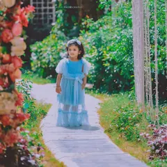 A real-life Cinderella story captured in a beautiful garden. The dreamy lighting and her elegant blue dress make this a truly magical photo.