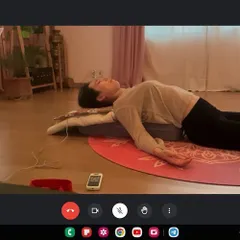Guiding a student through a supported restorative pose during an online consultation. Using props like bolsters is crucial for relaxation, and I can instruct on how to use them effectively even through a screen.