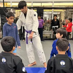 Coach Shaun, a BJJ brown belt, instructs his students on the fundamentals of posture and control. Clear instruction is key to helping children understand the core concepts of Jiu-Jitsu.