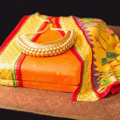 An orange Paithani saree cake, created for Navratri, complete with an edible golden necklace.