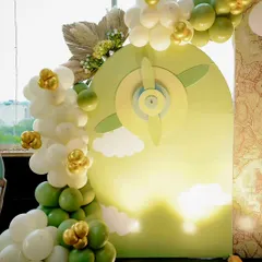 A custom 3D propeller backdrop for a travel-themed baby shower. This was specially designed for a pilot couple, with a balloon garland in sage green, white, and gold adding to the celebratory feel.