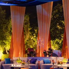 A lounge area from the 'Fire and Ice' event, where drapes of orange and blue fabric create a dramatic canopy. The comfortable seating is accented with pillows in the theme's colors, ensuring a cohesive look.