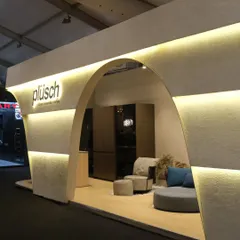 This angle highlights the inviting curve of the main arch and the way it frames the interior display. The design is subtle yet striking, a physical manifestation of the Plüsch brand's ethos.