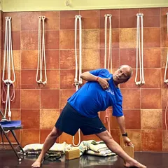 A demonstration of Utthita Trikonasana (Triangle Pose) using a block for hand support. This ensures the chest remains open and the spine stays aligned, which is the true purpose of the asana.