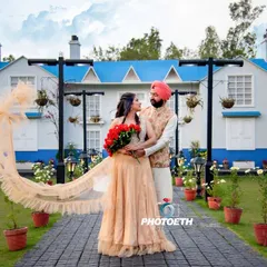 A stunning pre-wedding portrait with a dramatic, flowing veil. The unique architecture and garden setting create a beautiful, almost European feel.