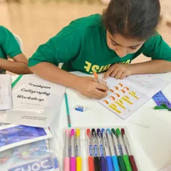 A young artist practices her lowercase 'p's, focusing on the thick downstrokes and thin upstrokes that are key to brush lettering.