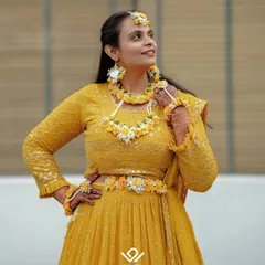 A stunning portrait of a bride dressed for her Haldi ceremony, adorned with beautiful floral jewelry.
