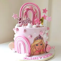 A dreamy two-tier Barbie cake for a first birthday, decorated in shades of pink with fondant rainbows, stars, and an edible image of Barbie. This design is perfect for a little one's special milestone.