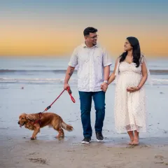 A sunset stroll on the beach with their four-legged family member. This photo captures the peaceful, happy moments before the new baby arrives.
