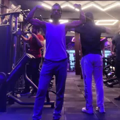 A full-body flex in the gym environment. This shows the overall athletic and lean physique that my integrated approach to fitness and nutrition aims to achieve. It's about being strong and functional.