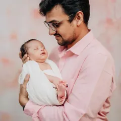 A father's gentle gaze at his sleeping newborn. These simple, emotional portraits highlight the profound connection between a parent and their child.