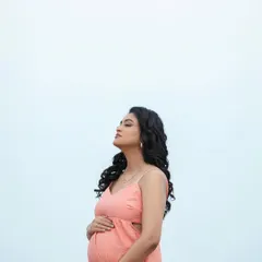 A moment of quiet reflection, feeling the sun and sea breeze. This minimalist shot against the sky highlights her beautiful profile and baby bump.