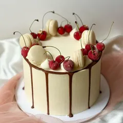 A duplicate image of the irresistible cherry and macaron drip cake, showcasing the glossy chocolate drip and fresh toppings.