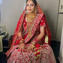 A full portrait of my stunning bride in a classic red lehenga. The makeup is centered around bold red lips and defined eyes, paired with heavy gold jewellery for a complete, traditional bridal look.