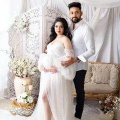 A glamorous mom-to-be celebrating her journey. I provide a collection of beautiful maternity gowns, like this elegant white dress, to make you feel absolutely radiant. This portrait was taken in my studio against a soft, dreamy backdrop.