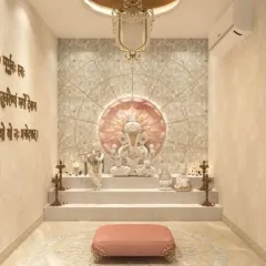 A tranquil pooja room featuring a multi-tiered platform for idols, set against a mother-of-pearl style lotus backdrop. The space is softened with warm lighting, and the walls include engraved Sanskrit shlokas for a complete spiritual experience.