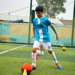 Ball control is key. Here, a player practices his close-control dribbling skills around cones, a fundamental drill in our training sessions.