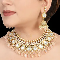 A lovely antique gold Kundan choker with soft pink beads. This set, which includes teardrop-shaped Kundan work and matching jhumkas, is perfect for a romantic, pastel-themed wedding.