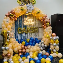 This birthday ring decoration features a "Happy Birthday" neon sign as the centerpiece. The sign glows brightly against the blue foil curtain and balloon arch.