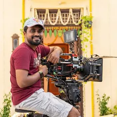 The Director of Photography (DOP) for the Shriram Finance ad, seated behind a fully rigged cinema camera. It's always a pleasure to work with and learn from talented crews.