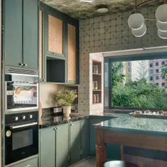 The large window in this kitchen does more than just bring in light; it connects the home to the lush greenery outside. The design embraces this view, making the act of cooking or sharing a meal feel open and refreshing.