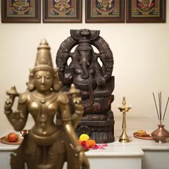 A beautifully carved Ganesha statue with a dark wood finish, shown here as the centerpiece of a serene pooja mandir. Its presence brings a sense of peace and divinity to the sacred space.