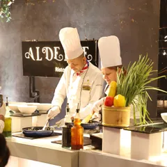 Our Italian chefs at the 'Al Dente' Ristorante station, bringing authentic flavours and techniques to your event. Here, they are in their element, pan-frying ingredients for a fresh pasta dish.