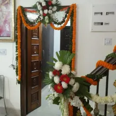 A simple and traditional flower decoration for a Grihaparvesh (housewarming) ceremony. We decorated the main door with marigold garlands and placed flower bouquets on the staircase railing to welcome guests.