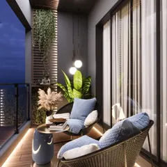This image captures a modern balcony at dusk, highlighting the importance of ambient lighting. Floor-level strip lighting and soft pendant lights create a warm, inviting glow on the wicker chairs and wooden deck, perfect for a quiet evening outdoors.