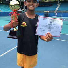 Celebrating a first-ever title! Laqshaya proudly holds his trophy after winning the U/10 tournament at KSLTA.