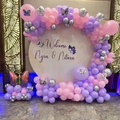 Welcome home the new princess, or two, with this beautiful butterfly-themed decoration. A circular backdrop personalized with the babies' names is framed by a pink, purple, and silver balloon arch with delicate butterfly accents.
