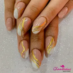A chic and glamorous design with a nude base, featuring abstract sections of white and gold glitter separated by a fine gold line.