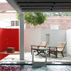 An open-to-sky courtyard and pool area from our conservation of Stuber Hall in Fort Kochi, a 1740s Dutch East India Company residence. We added contemporary elements like this bold red wall while preserving the home's historic character, creating a dialogue between old and new.