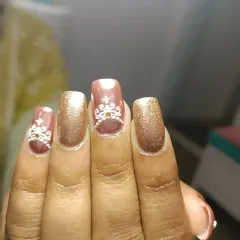 A close-up of the detailed white henna-inspired art on these rose gold bridal nails. The fine lines and patterns are drawn by hand to create a truly unique and coordinated look for the wedding.