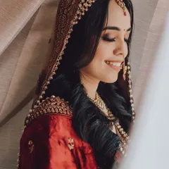 A beautiful close-up of a bride with her eyes closed, smiling softly. This portrait captures a moment of serene happiness.