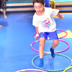 A young camper navigates a hula hoop obstacle course. My active camps are designed to improve agility and coordination through fun, structured games that keep kids moving and engaged.