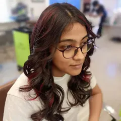This student's work showcases soft curls combined with subtle red highlights. You will learn how to place color strategically to enhance a haircut and add dimension.