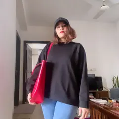 My official welcome to winter. A cozy black sweatshirt, comfortable jeans, and a baseball cap are my essentials. I add a pop of color with a bright red tote bag to liven up a gray day.