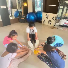 Young students in my Kolkata dance class work on their forward folds and group stretches. We always start with a proper warm-up to build flexibility and prevent injuries.