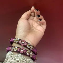These simple purple velvet bangles are decorated with kundan and meenakari floral motifs. They are elegant enough to be worn alone and are also great for gifting.