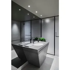 The gym washroom in 'The Bandra Project' follows a sleek grey, white, and black color palette. The angled vanity mirrors the building's geometry, creating a cohesive design language throughout the common areas.
