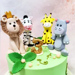 A detailed close-up of the handcrafted jungle animal toppers, showcasing their playful expressions and unique features.