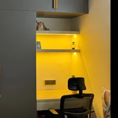 A closer look at the integrated study nook, showing the desk space, power outlets, and warm ambient lighting.