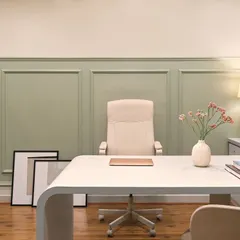 The main desk area in my office, featuring a minimalist white desk and a comfortable, high-back chair. The sage green wall paneling adds a touch of color and sophistication, reflecting the Furbishy brand aesthetic.