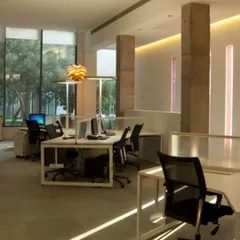 The interior of the Delhi experience center, designed to be a functional yet elegant gallery space. We used exposed concrete pillars and strategic lighting to highlight the art and create an open, airy environment filled with natural light.